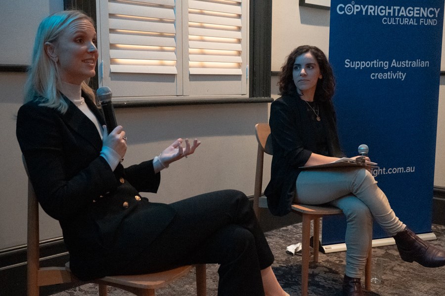 Alexis Daish seated, speaking at the front of a room with with Edit host Matilda Marozzi